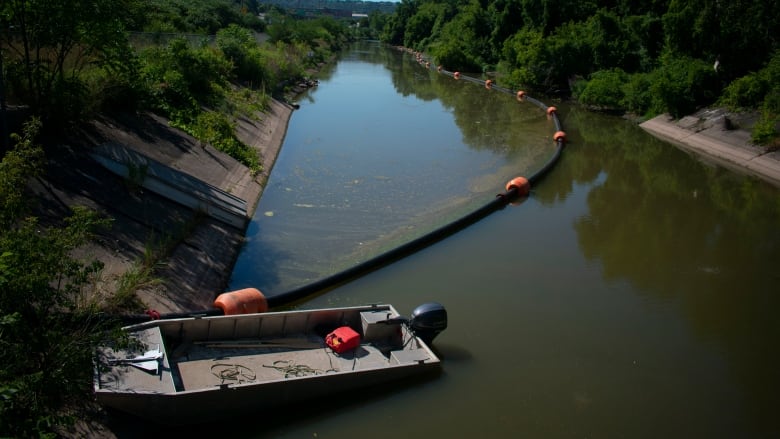 A boat and a tube sit in a water way