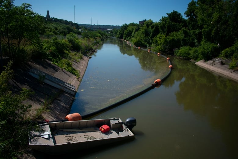 A boat and a tube sit in a water way