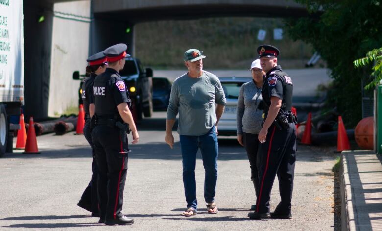 A group of officers speak to Deltor.