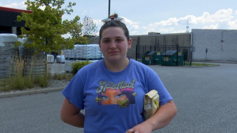 A woman with her sunglasses on her head wearing a blue t-shirt