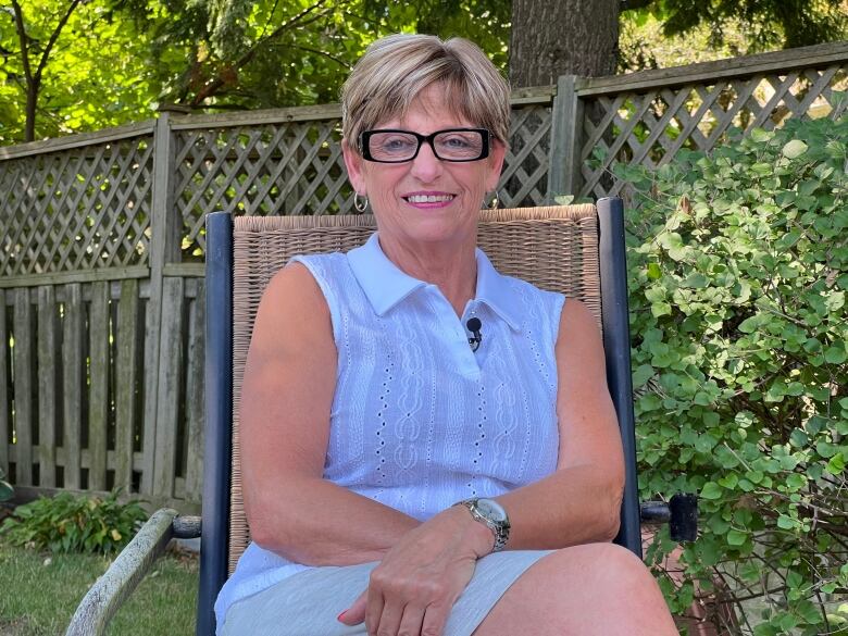 Heidi Allison sits and smiles in a back yard in Leamington