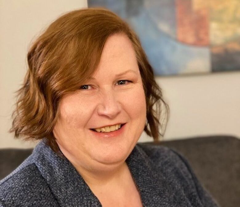 A woman smiles in an office.