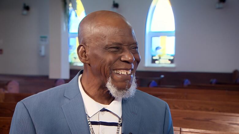 Rev. Wallace Smith Sr. smiles during an interview inside a church.