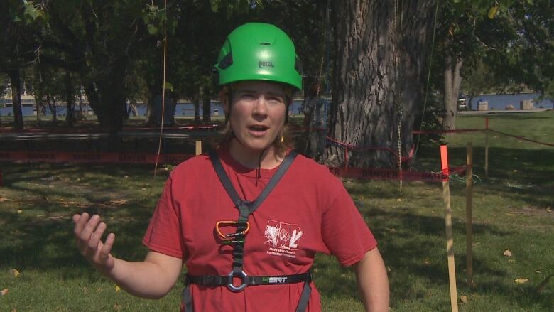 Woman stands with helmet and harness on