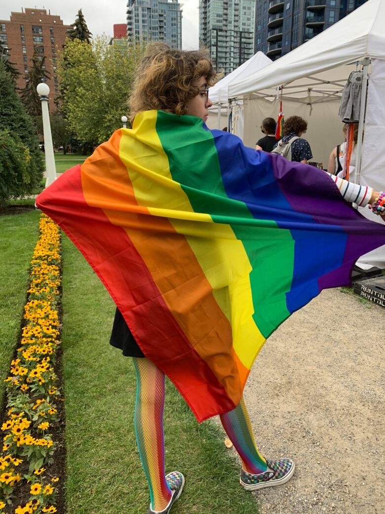 A person is seen holding a brightly colored flag.