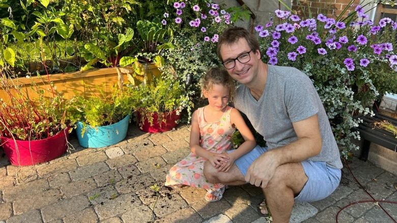 Beatrice and Cameron Wallis in front of their garden