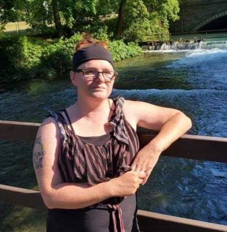 A woman stands on a bridge. 