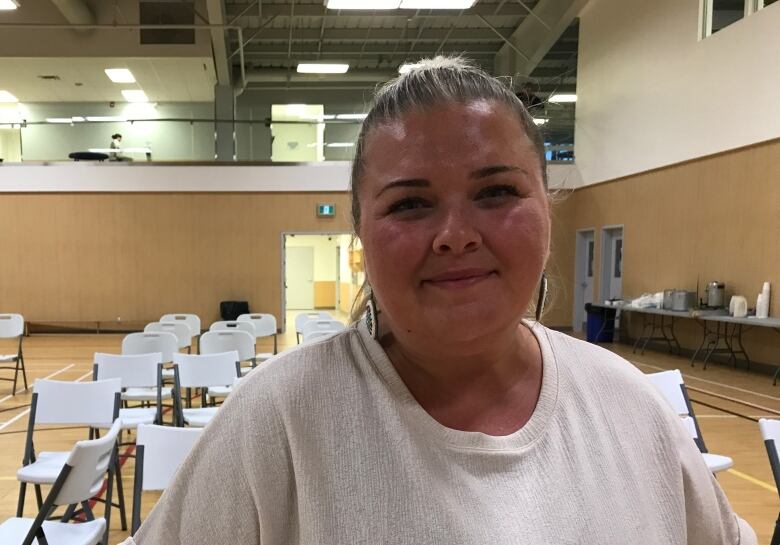 A portrait of a woman in a room with a lot of chairs.