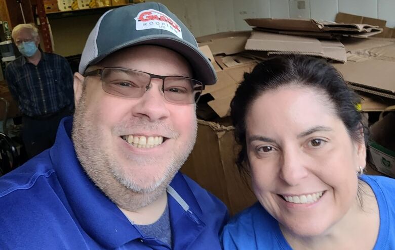 A man in a hat and a woman pose for a selfie.