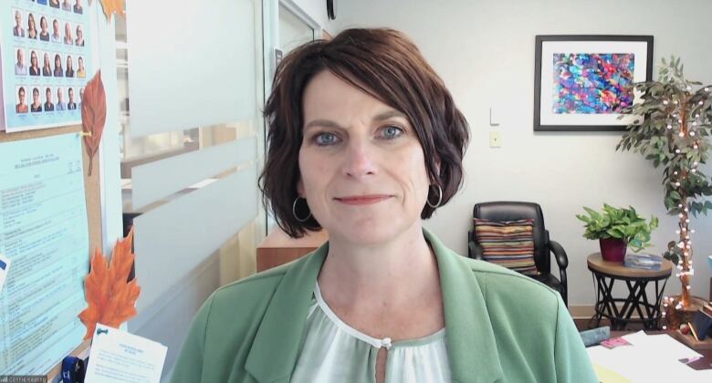 A woman with short hair wearing light green