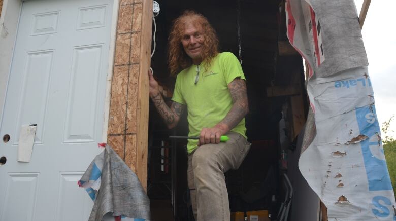 56-year-old Charles Sule stands in the doorway of the house he's building in the northern Ontario bush. 