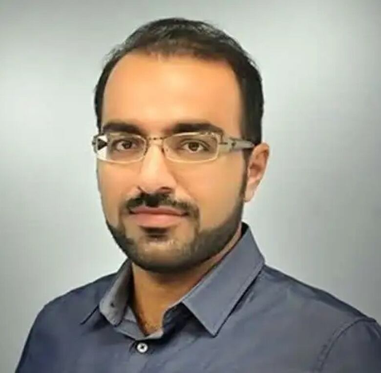 Portrait of man with facial hair, glasses.