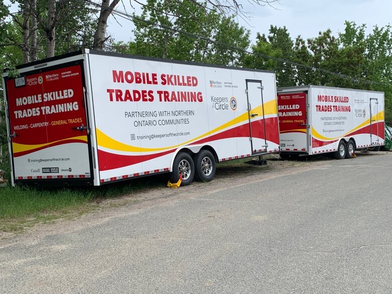 Two trailers are parked by the road side.