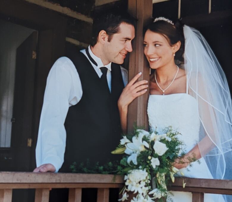 In an old photo, a clean-shaven Noel smiles at his wife in a wedding gown.