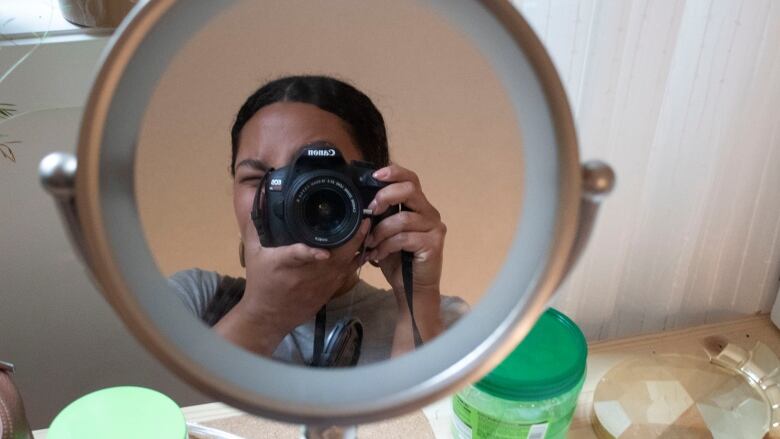 A woman takes a picture of herself in a mirror.