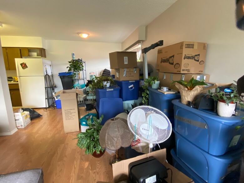 Moving boxes and a ceiling fan piled up in a home.