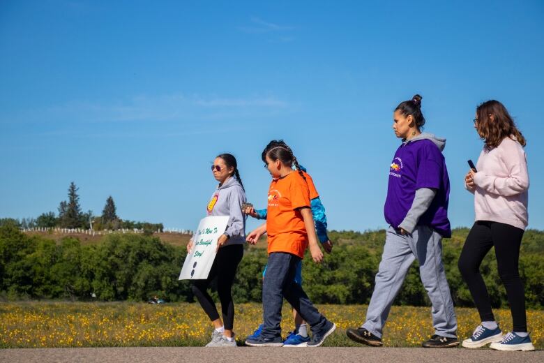 Students walk holding signs for World Suicide Prevention Day.