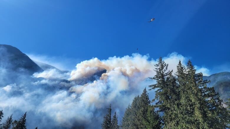 A large amount of smoke is seen rising from hilltops.