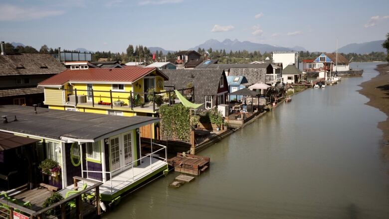 A number of float homes are pictured along a river.