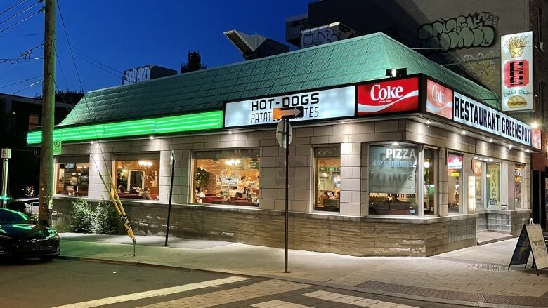 A diner advertising Coke and hot dogs. 