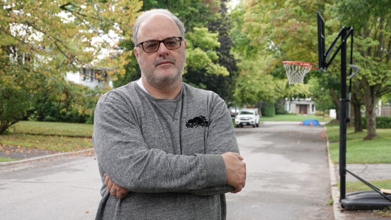 Picture of resident Drew Enright standing with his arms crossed on the street where his neighbour's dog was attacked.