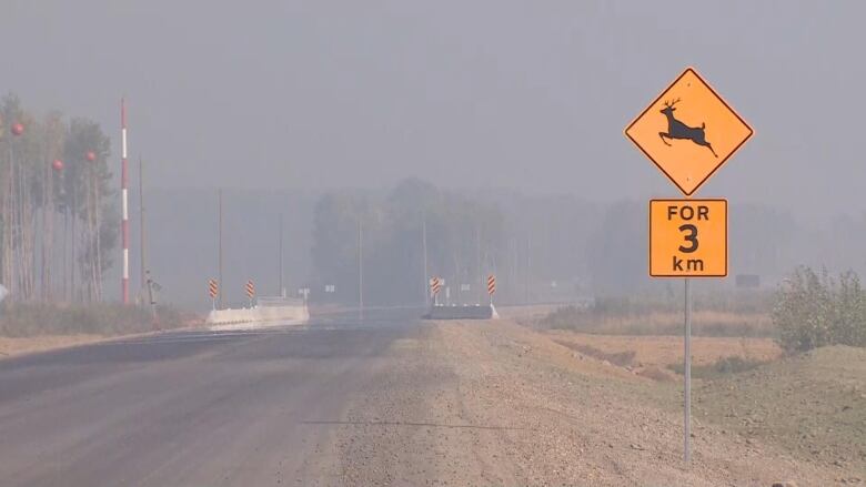 Smoke lingers over a road.