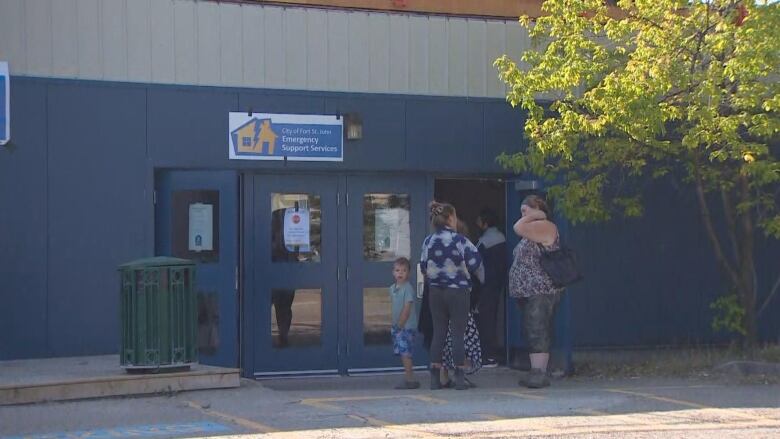 People stand in line outside a building.