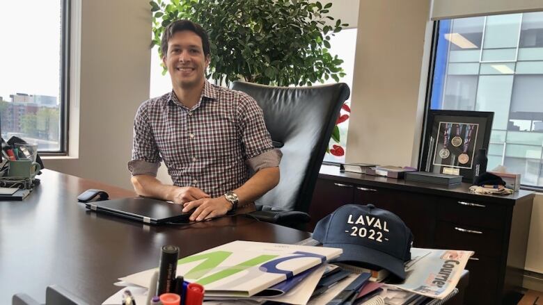 A man is sitting behind his desk.