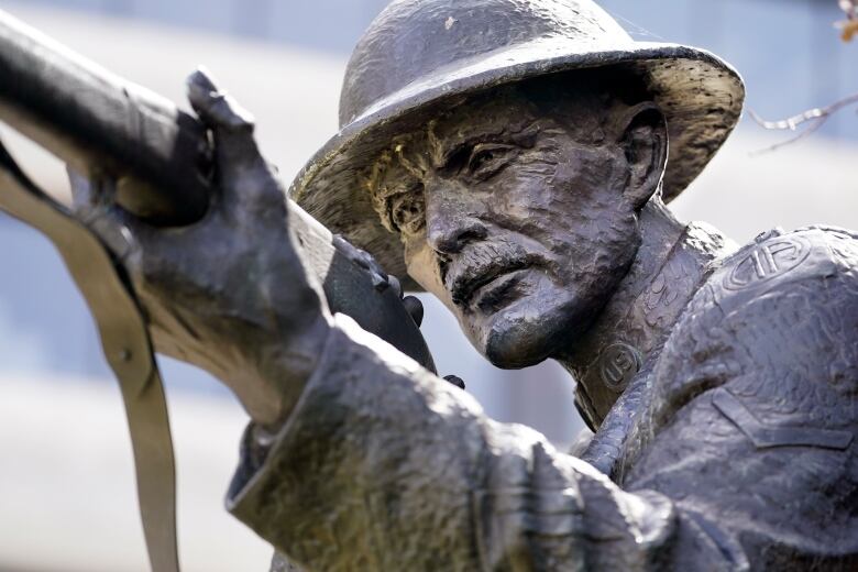 A statue of a man pointing a bayonette and looking through the sights.