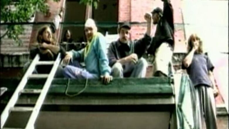 A number of young people look snappy as they lay atop a ladder on a loft.