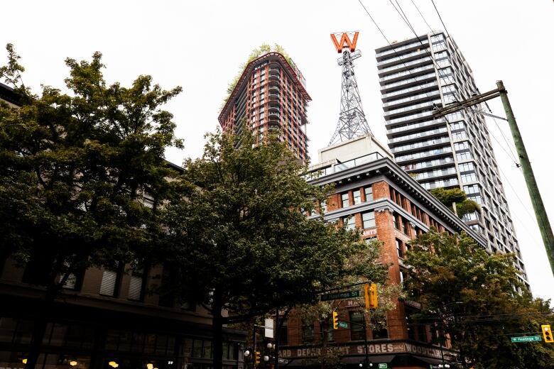 A large 'W' symbol sits atop an Eiffel-tower-like structure atop a brick building.