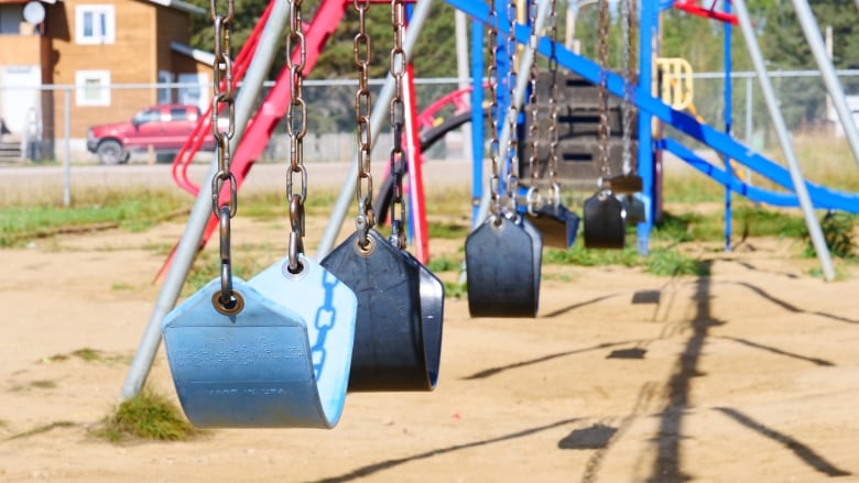 Playground swings are shown in front of a play structure.