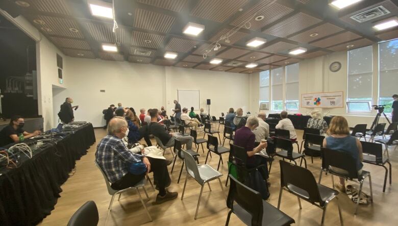 Room with seating organized  in rows to face a main table. 