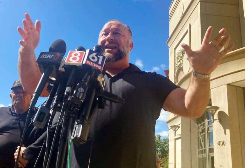 Alex Jones speaking outside a courthouse. 