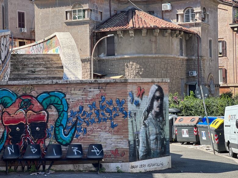 An Italian neighbourhood. There is graffiti on the wall.