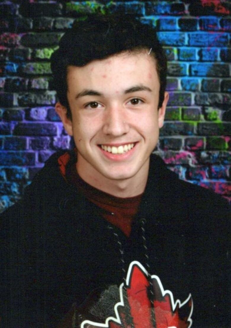 A young man smiling in a posed photo.