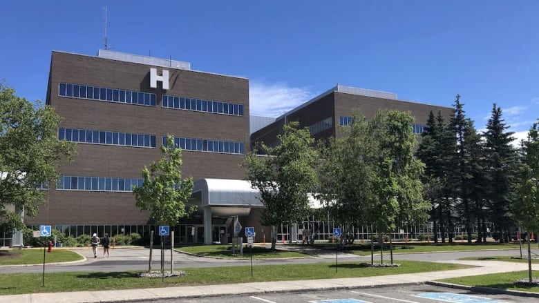 A large brown building with a large letter 'H' at the top.