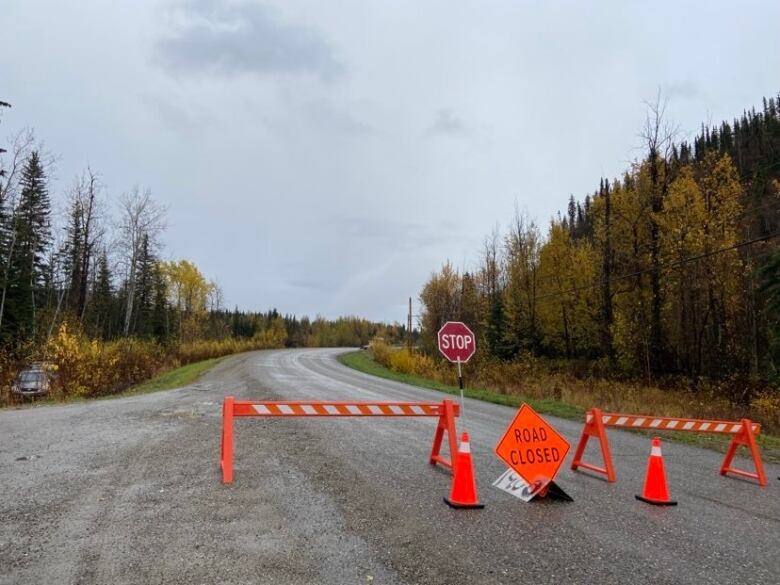 Orange barracades are set up on the highway blocking public access to landslide area.