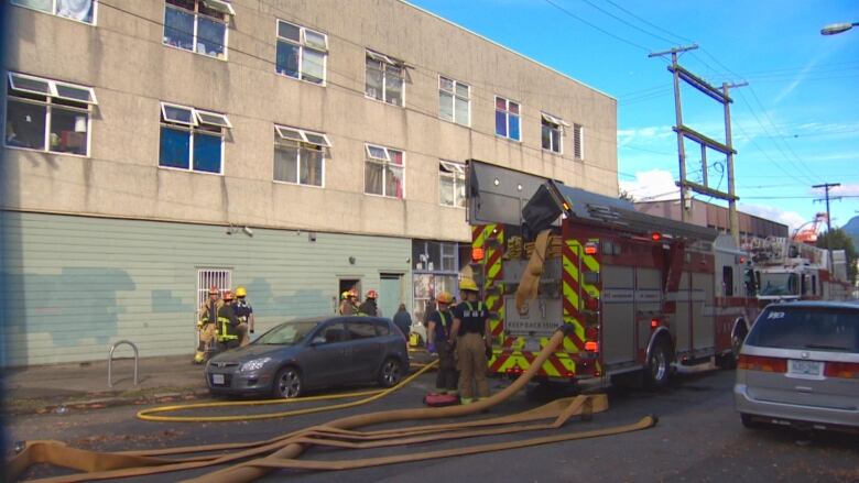 A fire truck sits in front of a small squat building.