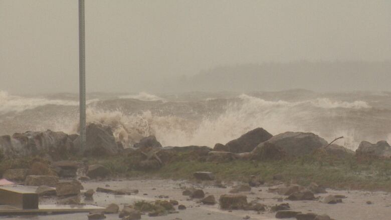 Waves crash on a rocky shoreline.