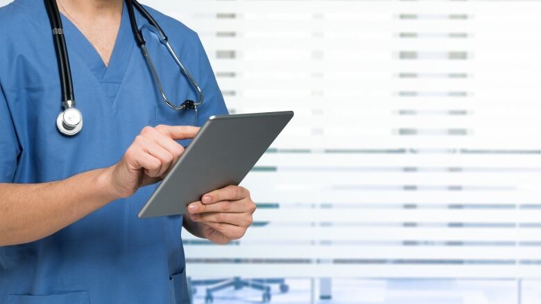 Stock image of a doctor or nurse using a tablet.