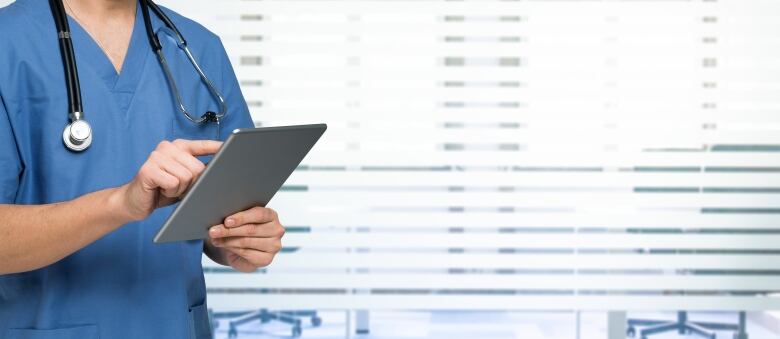 Stock image of a doctor or nurse using a tablet.