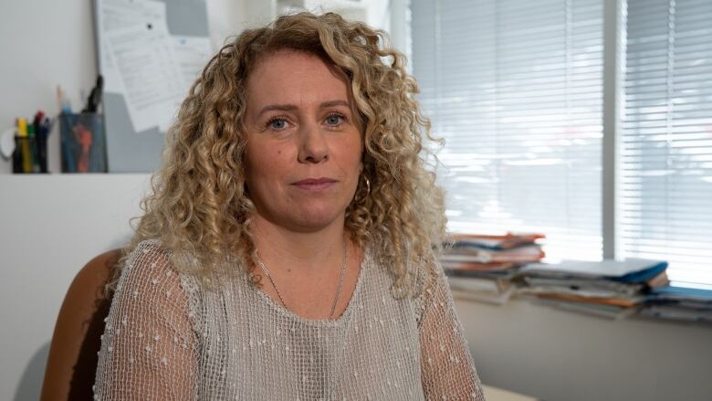 A woman poses for a photo in an office.