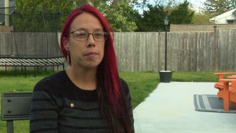 A woman with red hair and glasses