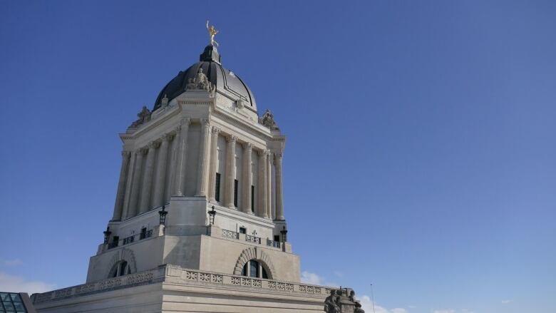 Looking up at the top of the legislative building, including the Golden Boy on top. 