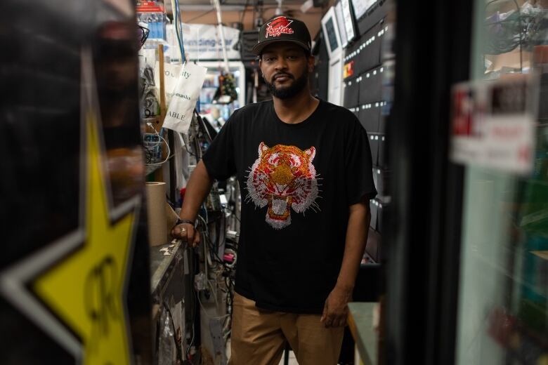 A portrait of a young Black men in a convenience store aisle.