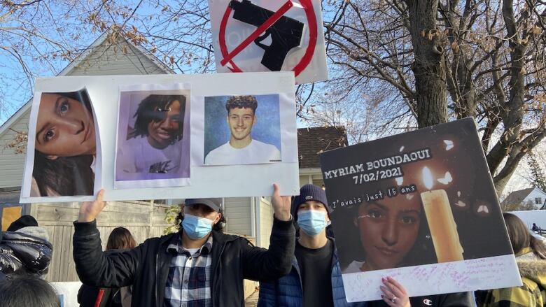 A group of people are holding anti-gun violence posters. 