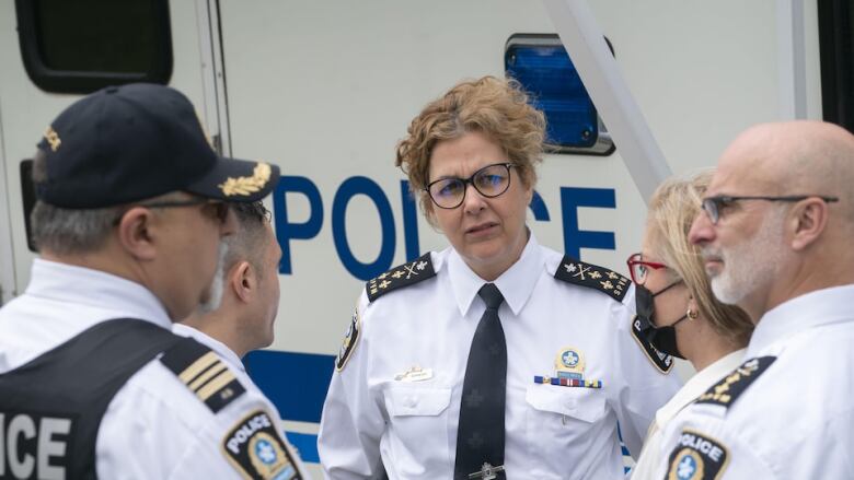 Four police officers look to Montreal police interim director Sophie Roy.