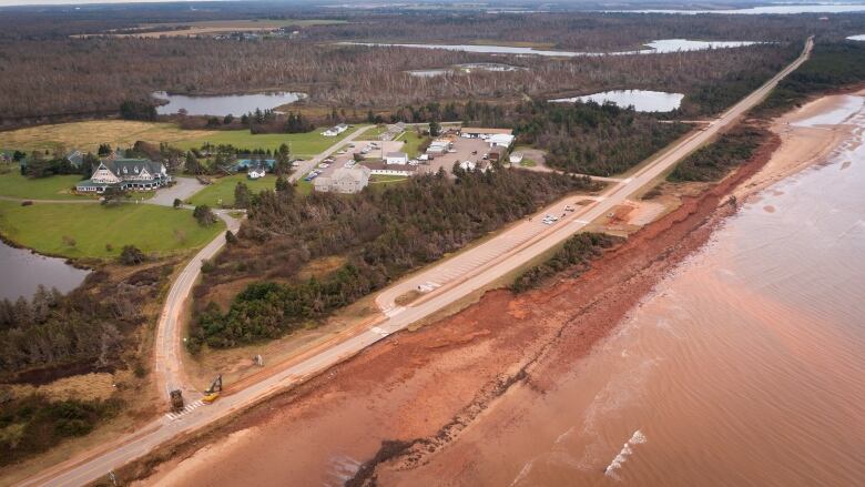 Drone shot of a road partly washed away after a storm surge. 