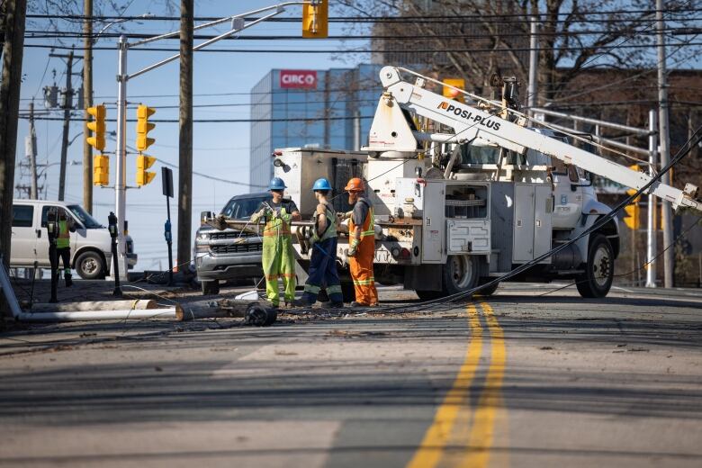 Power crews repair a downed line in a city street.